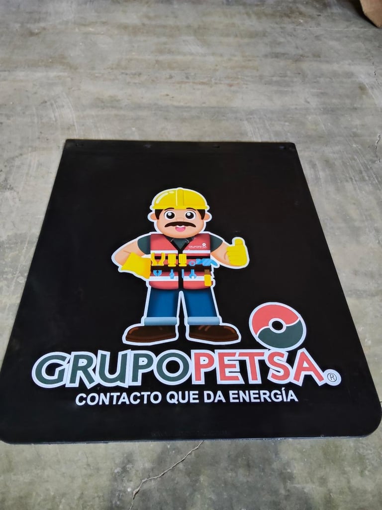 Black mat featuring cartoon construction worker mascot with yellow hard hat and Grupo Petsa logo with Spanish tagline