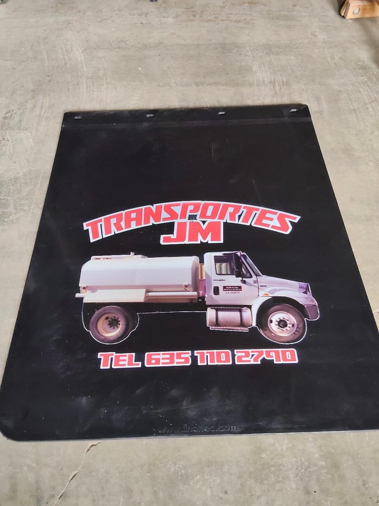 Black truck mud flap with Transportes JM logo featuring a white and red tanker truck and phone number