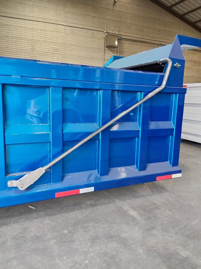 Blue industrial skip bin or waste container with metal chute attachment in warehouse