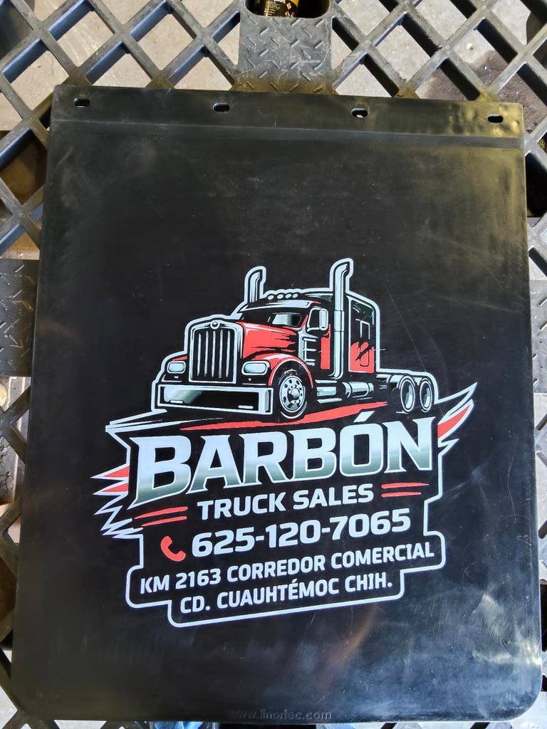 Black mud flap with Barbon Truck Sales logo featuring a red semi-truck, contact number and address