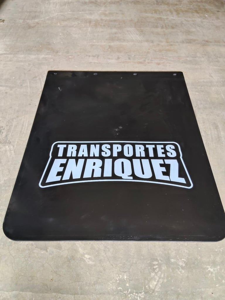 Black rubber mudflap with white Transportes Enriquez logo on concrete surface