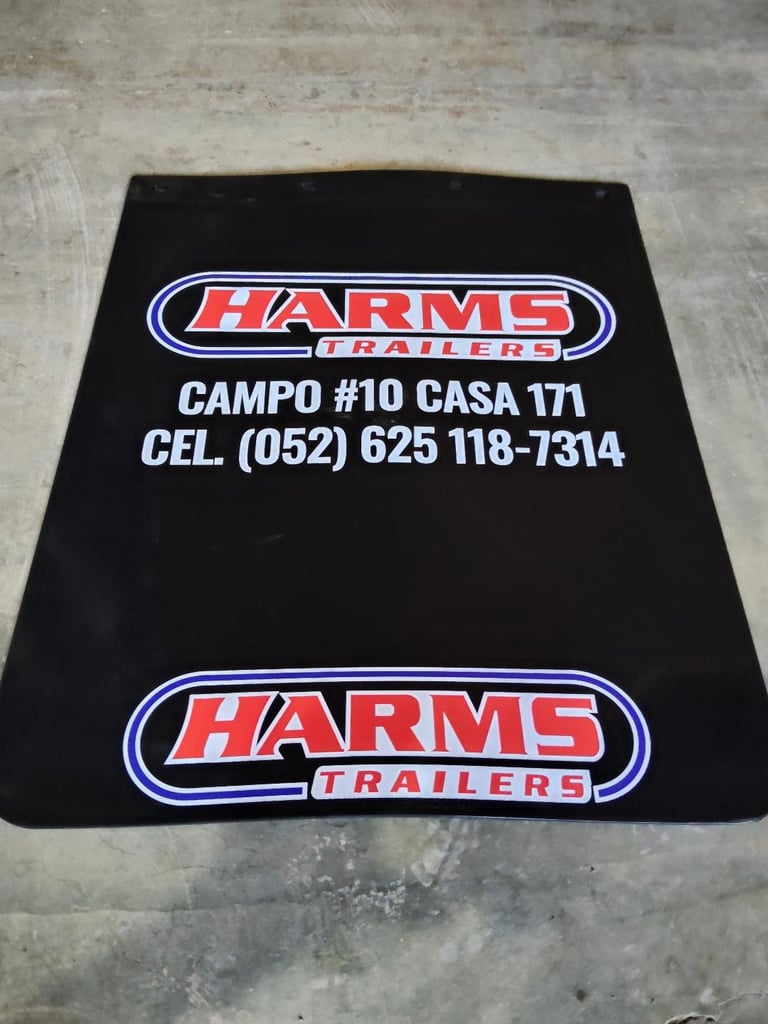 Black mud flap for Harms Trailers with logo and contact information including Campo #10 Casa 171 and phone number